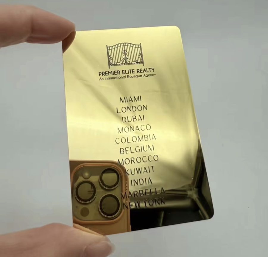 Mirror gold card with engraved line-art logo and list of cities